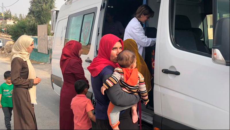Mujeres junto a sus hijos siendo atendidas por la clínica móvil. Fotografía: Manos Unidas